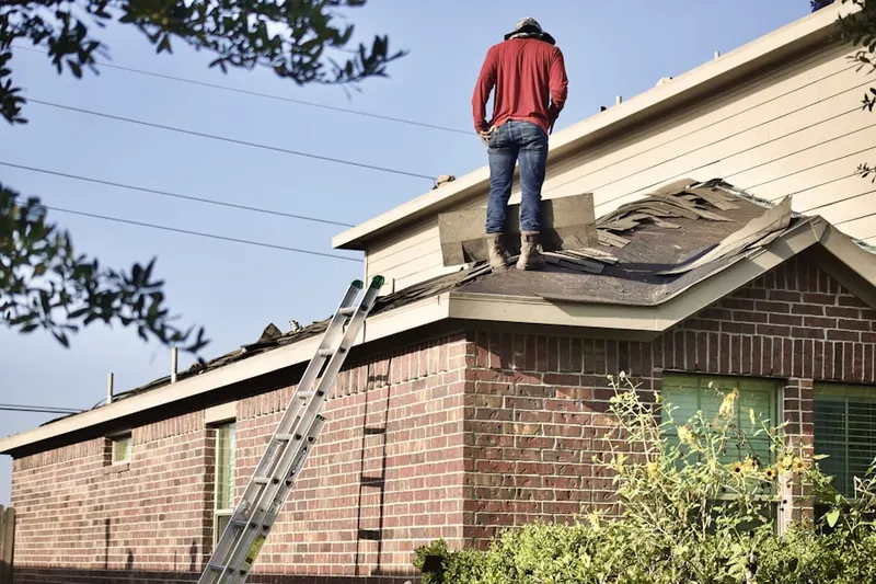 Professional roofer working on a residential roof in Sayre Woods
